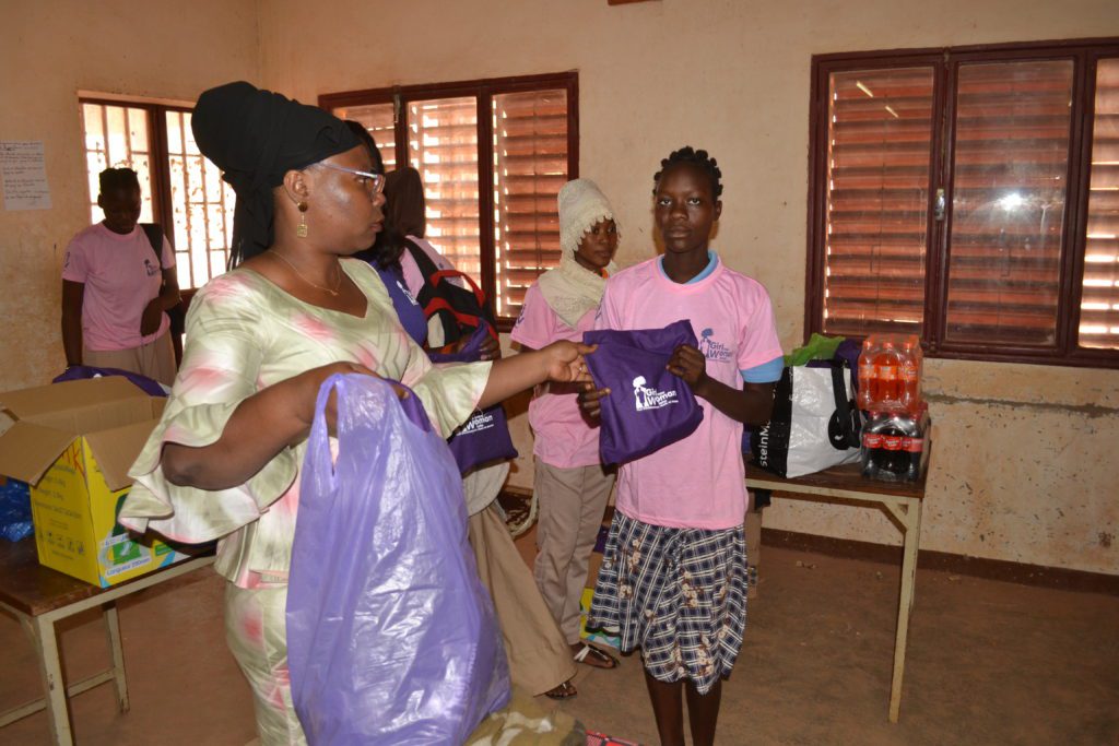 Girls receiving purple Girl Now Woman Later period kits in a our menstrual education workshop in Burkina Faso, Africa