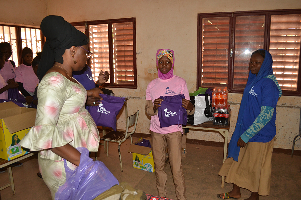 Girls receiving purple Girl Now Woman Later period kits in a our menstrual education workshop in Burkina Faso, Africa