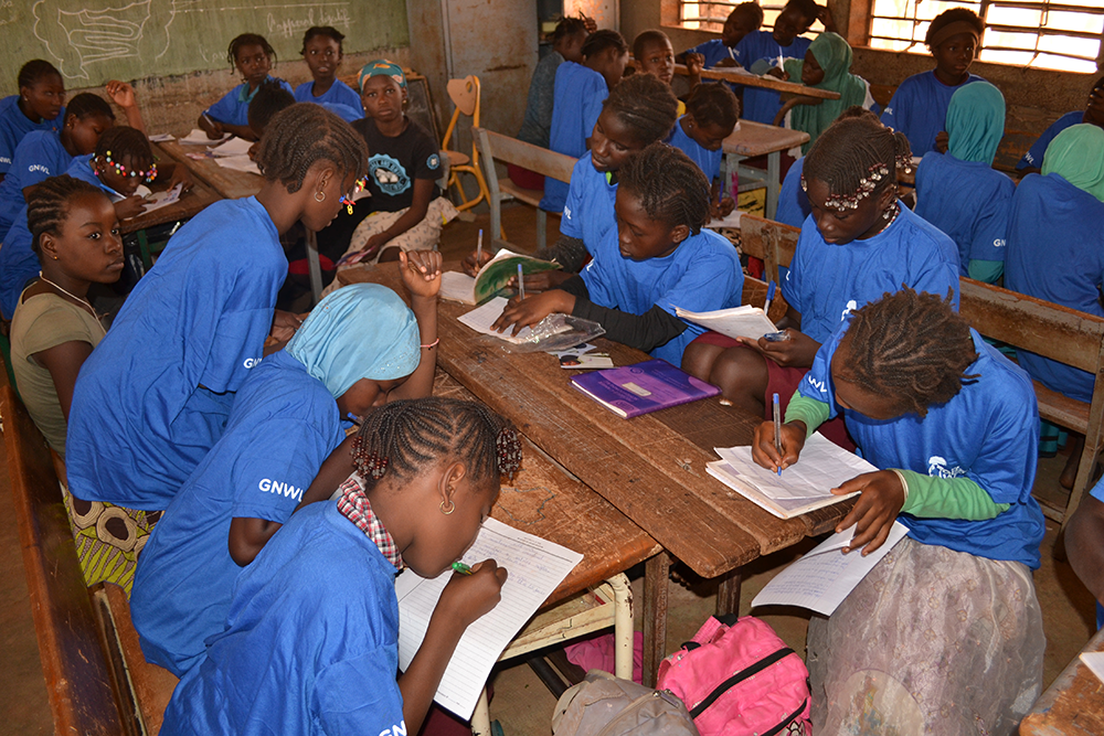 Girls writing in their notebooks at our menstrual education workshop in Nord-C school in Burkina Faso, West Africa.
