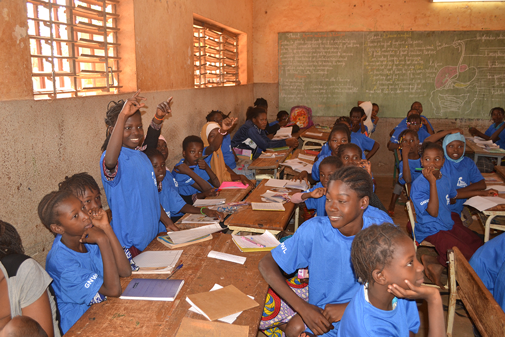 Girls raising their hands at our period education workshop in Nord-C school in Burkina Faso, West Africa.