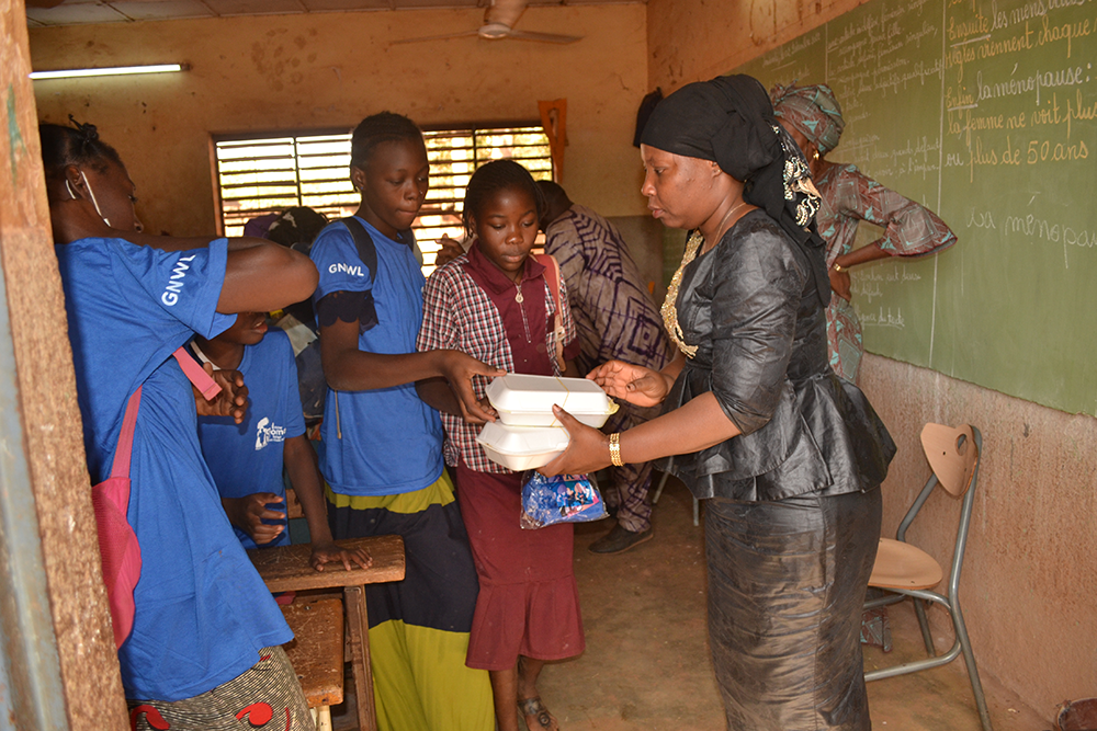 Sakande Koanda Sanata, handing out lunches to students during one of the period education classes.